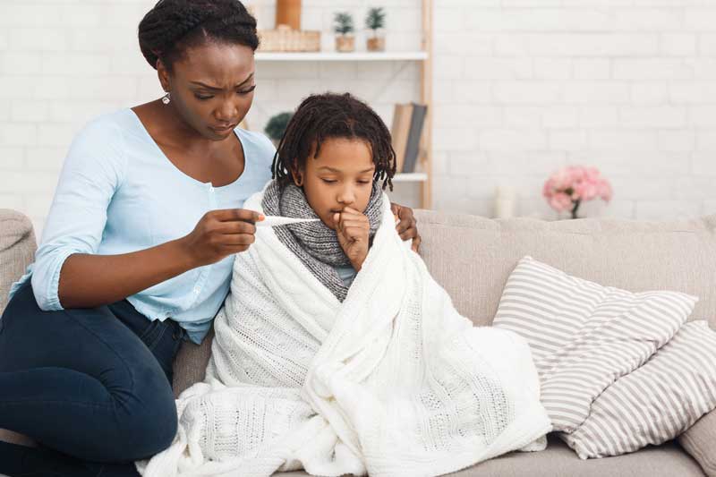afro-mum-measuring-temperature-of-coughing-kid
